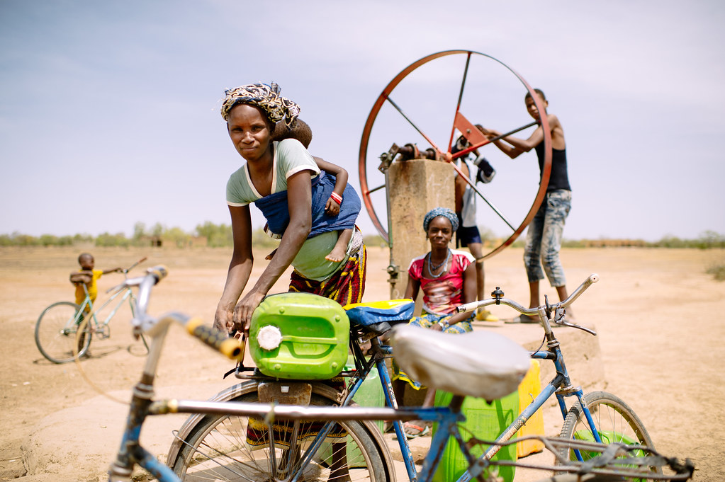 Barry Aliman, 24 years old, bicycles with her baby to fetch water for her family, Sorobouly village near Boromo, Burkina...