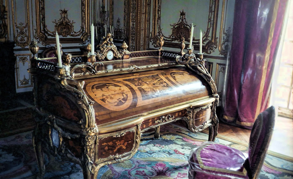 King's desk at Palace of Versailles: A medium-wood desk with four candles along the top and various flourishes throughout the piece.