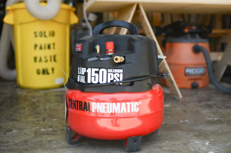harbor freight's red/black air compressor in a wood shop