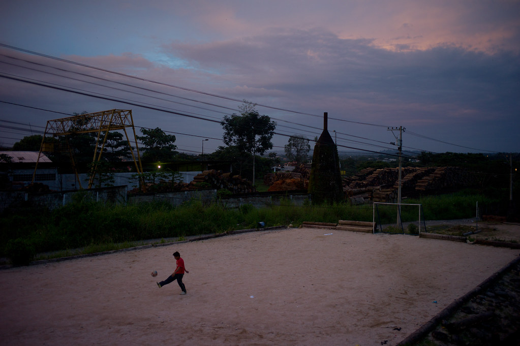 A child plays soccer next to a timber processing plant in Puyo, Ecuador.