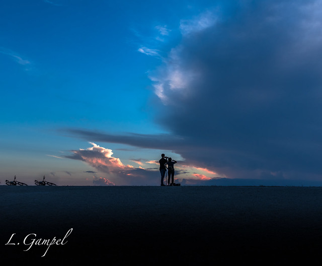 Couple photographing a dramatic sunset