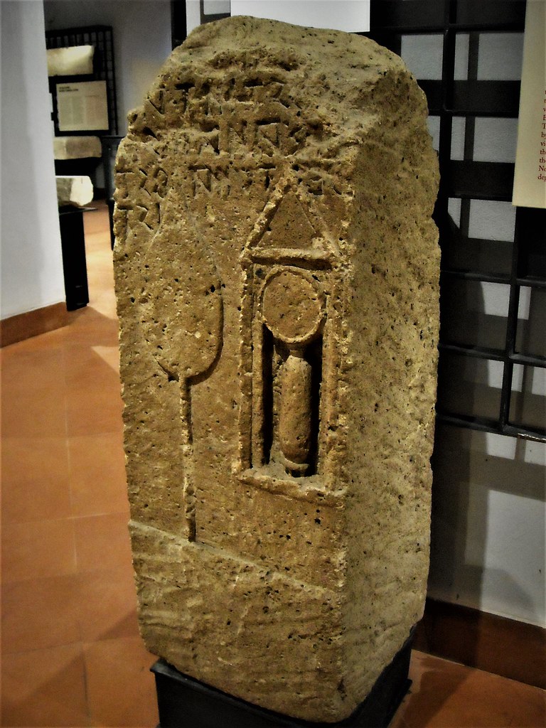 Stele. On it are represented in bas-relief a flabellum and a small box containing an ointment-holder and a mirror - Tuff (2nd century BC) from Cuma - Inscription in oscan alphabet, written to right to left: 