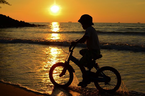 sunset beach borneo cycling bicycle boy shadow orange sea bintulu sarawak water