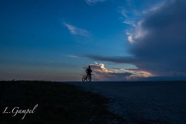 Biker watching dramatic sunset