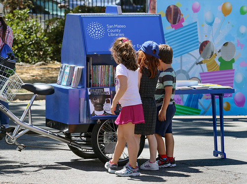 Children looking at books on the Book Bike.