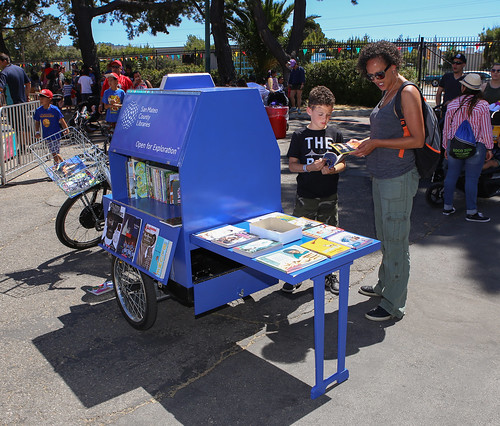 Mom and son looking at books on the book bike.