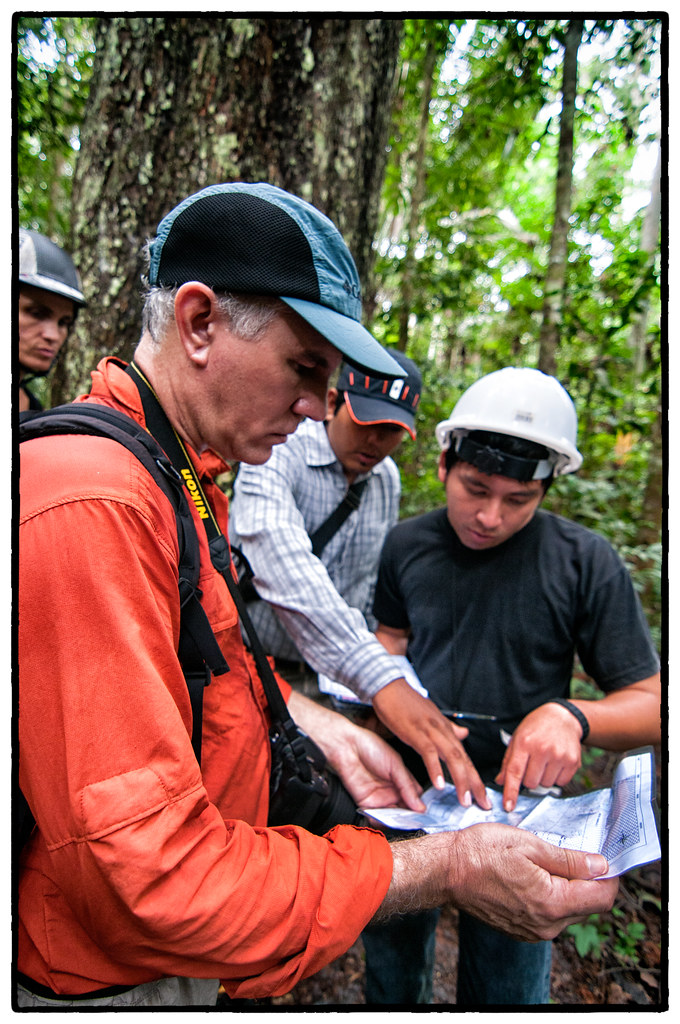 Center for International Forestry Research (CIFOR) scientists examining maps of Felicitas Ramirez Surco's Brazil nut concession, near Puerto Maldonado, Madre...