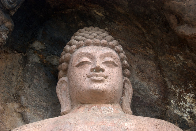 The carved face of Buddha looking content