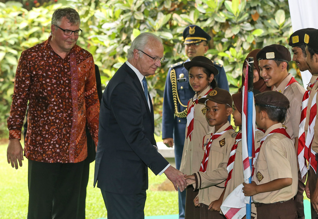 King Carl XVI Gustaf of Sweden, center, shakes hands with members of Indonesian Boyscout Movement as CIFOR Director General Peter...