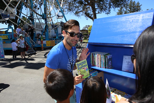 SMCL staff showing children books from the book bike.