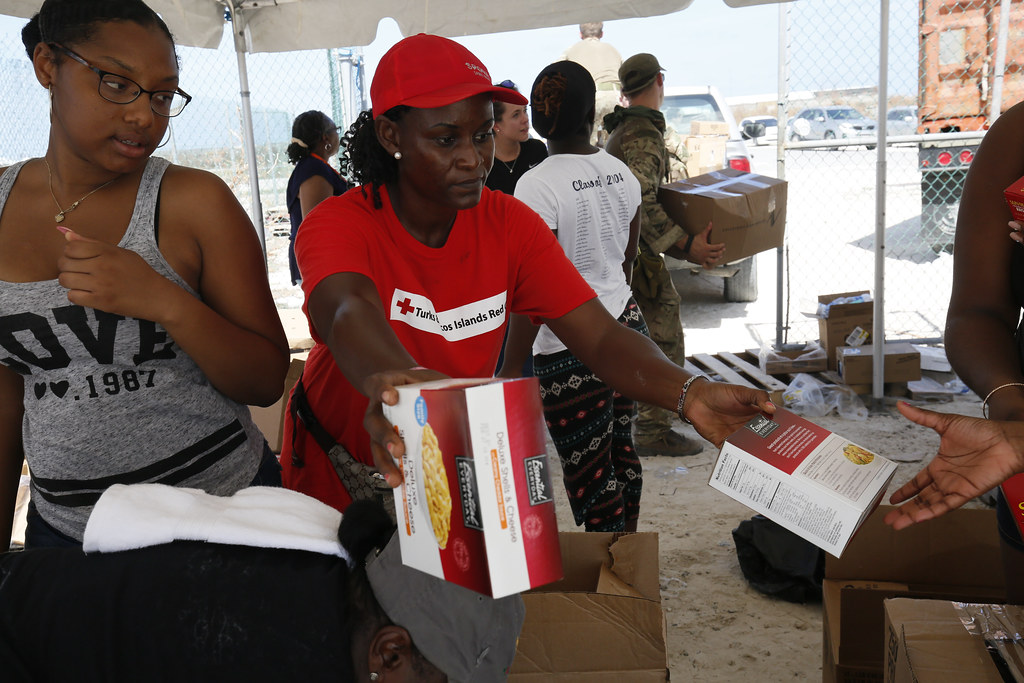 A Red Cross volunteer hands out food aid at a distribution for people affected by Hurricane Irma on Grand Turk, in the Turks and Caicos Islands.