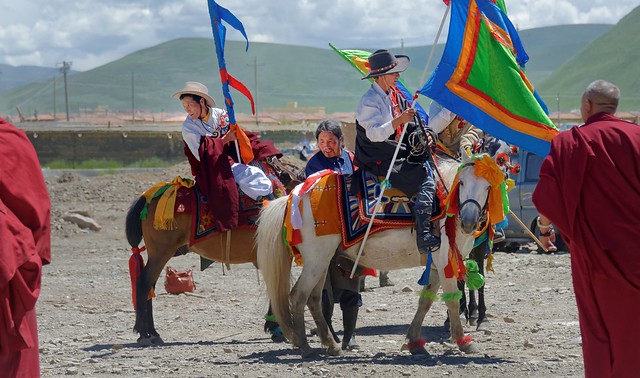 Flag bearers on on horseback in front of the Sershul temple, Tibet 2014