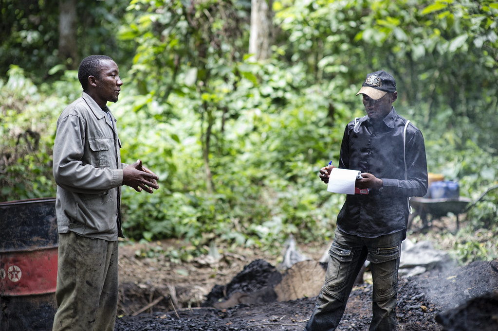 Patrice Metennou Researcher for Center for International Forestry Research (CIFOR) interviewing Cyprien Mvondo a charcoal burner from the Ovangoul village,...