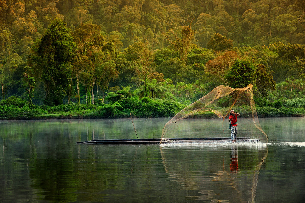 Local people of Gede Pangrango, Dadin, a 45 year old man, fishing in the lake using a traditional net.