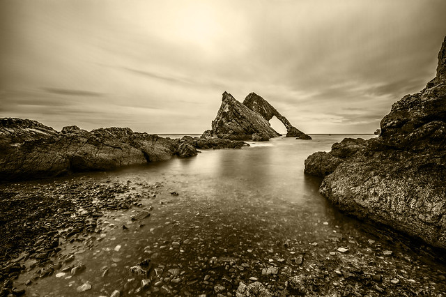 fine art black & white moody long exposure shot of Bow Fiddle Rock, Moray, Scotland