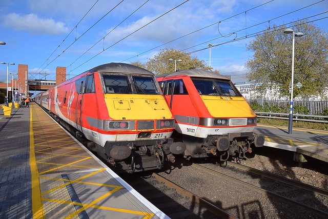 91117 heads the 1105 Leeds - Kings Cross Service, with the train in reverse formation, whilst the 1235 Kings Cross - Leeds service headed by  91119  makes its booked stop alongside at Stevenage. 29 10 2017