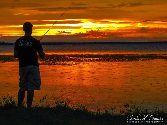 ANGLER’S GOLDEN SERENITY:  Taken at Choke Canyon State Park, in South Texas, during a family camping trip.  My nephew was fishing from the lake shore at sunset, as a light rain shower moved through.