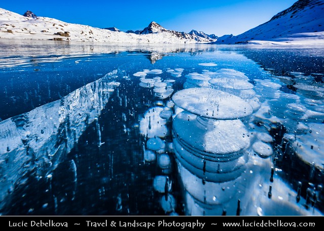 Switzerland - Alps - Deep frozen Lago Bianco - White Lake with surreal bubbles and long ice crack