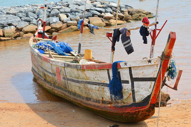 DUGOUT CANOE ON THE BEACH IN THE FISHING VILLAGE, TAKORADI,  GHANA.