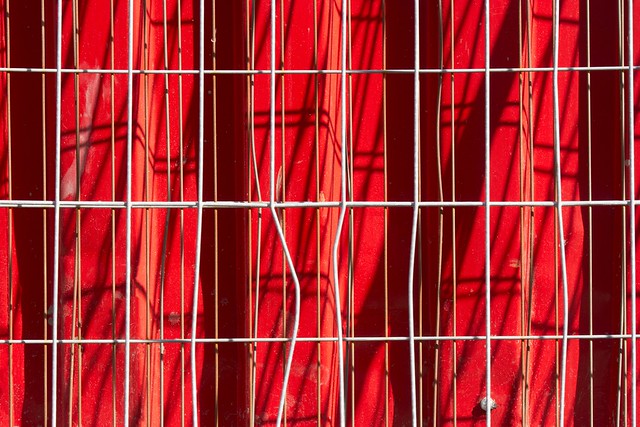Fence, shadows and red wall