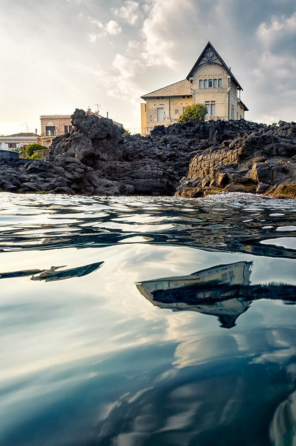 Beautiful luxury houses reflected over the sea at sunset, Catania, Italy