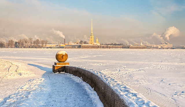 Saint Petersburg, Russia. The Spit of Vasilievsky island at a hazy frosty winter day. The view of The Peter and Paul fortress, the parapet and the granite ball. Shot from the descent to the water.