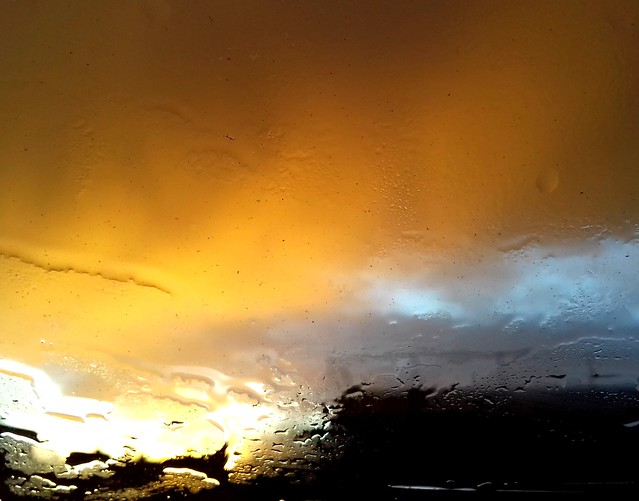 von Osten sehe ich die Sonne durch die Regentropfen, die sich auf dem Dachlukenfenster sammeln...
