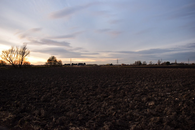 Sun sets over a ploughed field