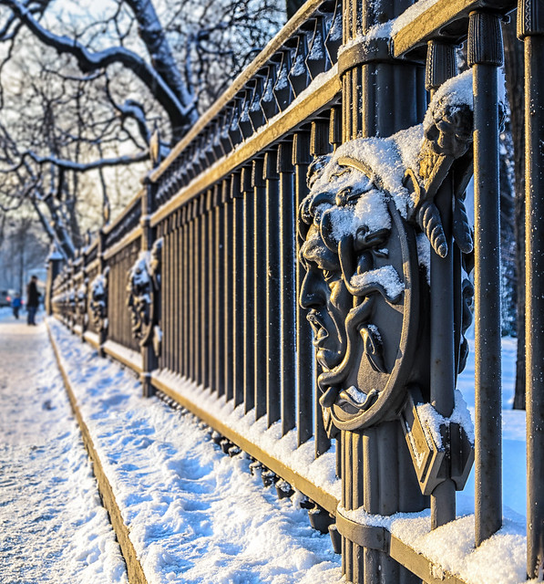 Saint Petersburg, Russia. A fragment of the fence of Letny Garden with the head of Gorgon Medussa under sparkling snow at sunny winter day