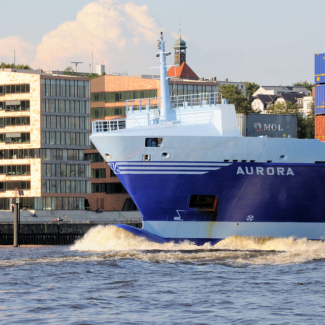 DSC_6953 Schiffsbug / Wulstbug des Containerfrachters / Feederschiffs Aurora auf der Elbe in Hamburg - im Hintergrund Bürogebäude in Neumühlen.