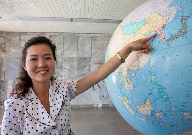 Female guide showing North Korea on a globe at Songdowon international children's camp, Kangwon Province, Wonsan, North Korea
