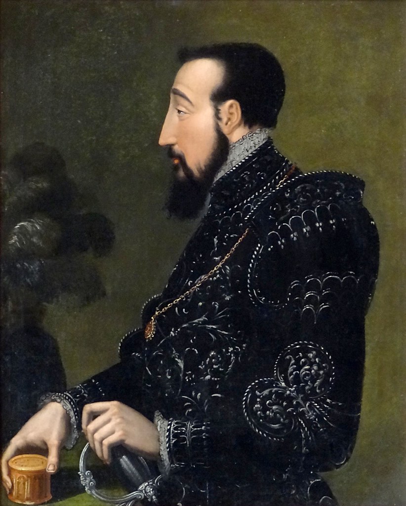 Henri II, king of France, portrait in a black outfit with dark facial hair and pale skin. 