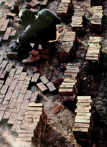 Facilties worker spaces out bricks during a project in the 1980s.