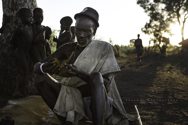 The chief of a village Bodi distributing tobacco among his people. Mago National Park, Ethiopia.