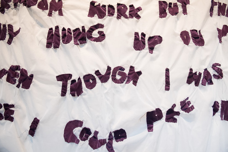 artwork with purple letterforms sewn on a white cloth