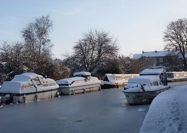 Boats under snowy blankets.