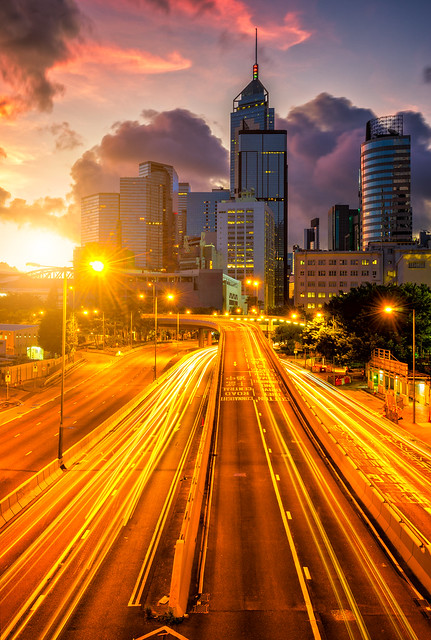 Traffic at central district in Hong Kong at sunrise time. Car light trails and urban cityscape in Hong Kong .