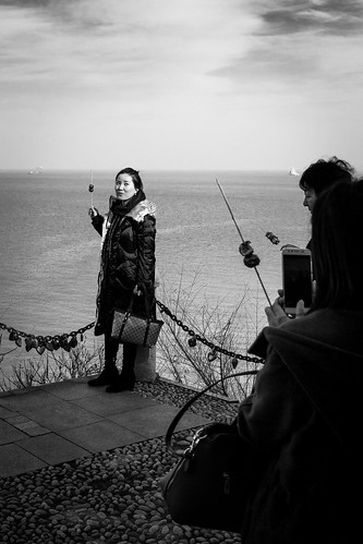 yantaishi shandongsheng chine cn yantai lady woman young portrait candid sea side shore view water spot boat cloudy sun clouds sunny shadow cold winter day hawthorn sugar skewer bag purse friends pose posing phone mobile cell cellular cellphone photo photography picture shoot shooting street urban city outside outdoor people bw bnw black white blackwhite blackandwhite monochrome naturallight natural light asia asian china chinese shandong canon eos 100d 24mm prime fun enjoy enjoying beauty beautiful