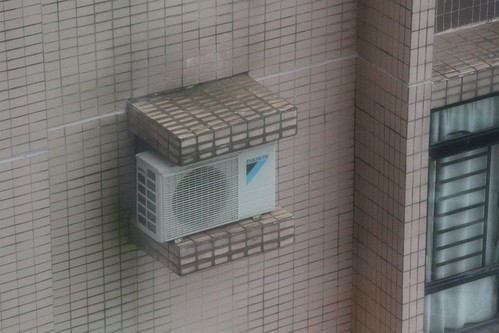 Split system air conditioner installed on a shelf designed for a through-wall unit