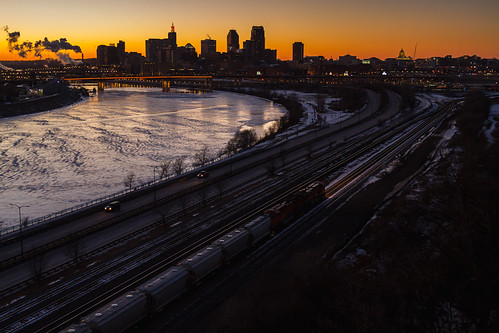 St. Paul Sundown by Ryan J Gaynor, Standing atop of Dayton's Bluff in St. Paul, Minnesota, a pair of BNSF GE's guide an autorack throug