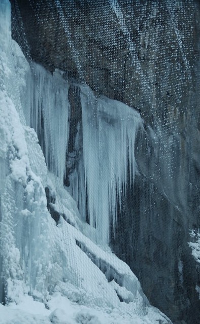 CLIFF HANGERS...ICICLES HANGING OFF THE ROCKS CLIFF. THERE ARE CHAINLINK CURTAINS COVERING THE CLIFF FACE.   HOPE PRINCETON HIGHWAY, MANNING PARK,  BC.