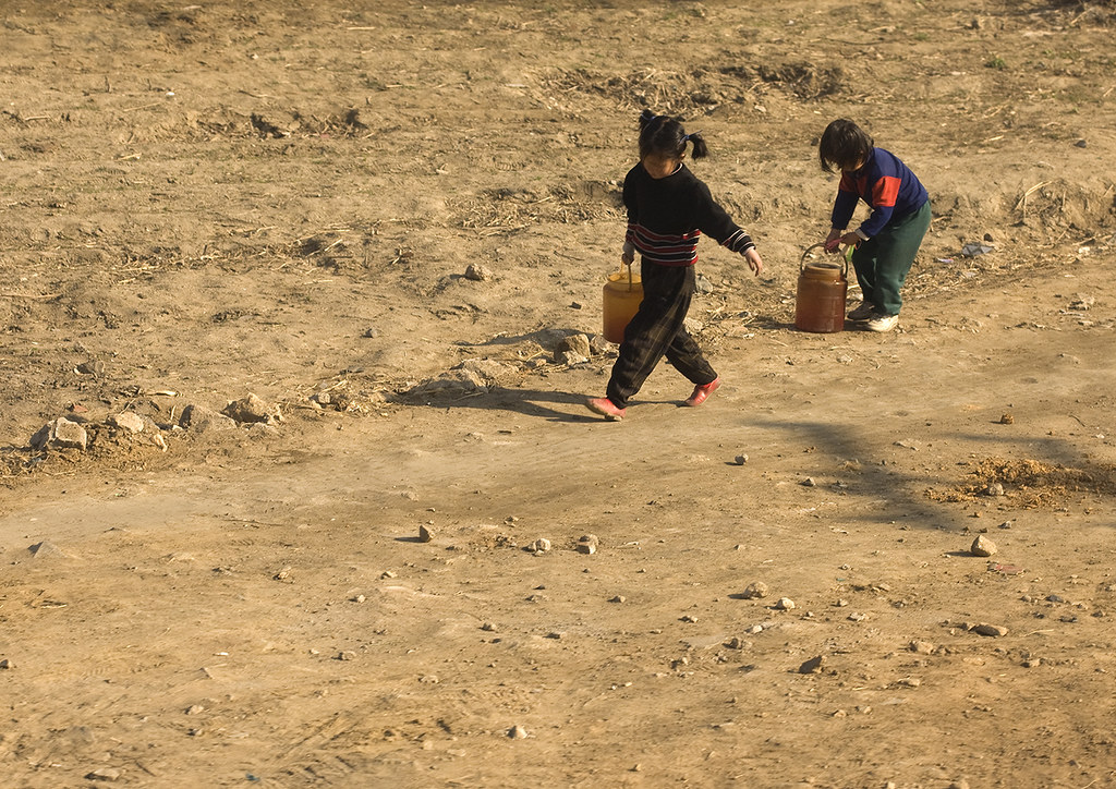 North Korean children bringing back buckets full of water from a well in the countryside, South Pyongan Province, Nampo, North Korea