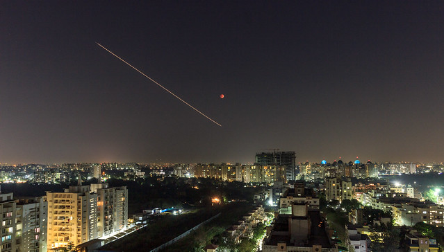 Plane Light Trail with Blood Moon