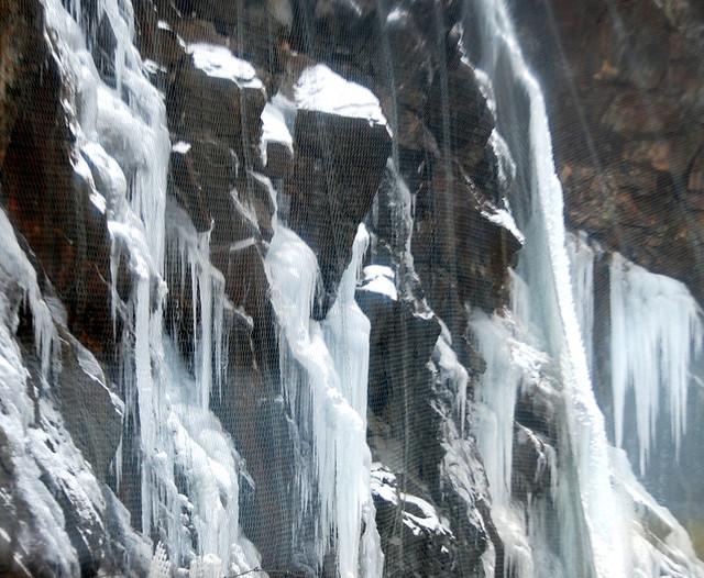 A CHAIN LINK CURTAIN DRAPING OVER A CLIFF THAT WEEPS MOISTURE......THE CURTAIN KEEPS THE ICE AND WET CONTAINED FOR SAFE DRIVING IN THE AREA....EXPENSIVE BUT UNIQUELY NORTHERN CASCADE AND HOPE PRINCETON WINTER DRIVING CONDITIONS...BC.
