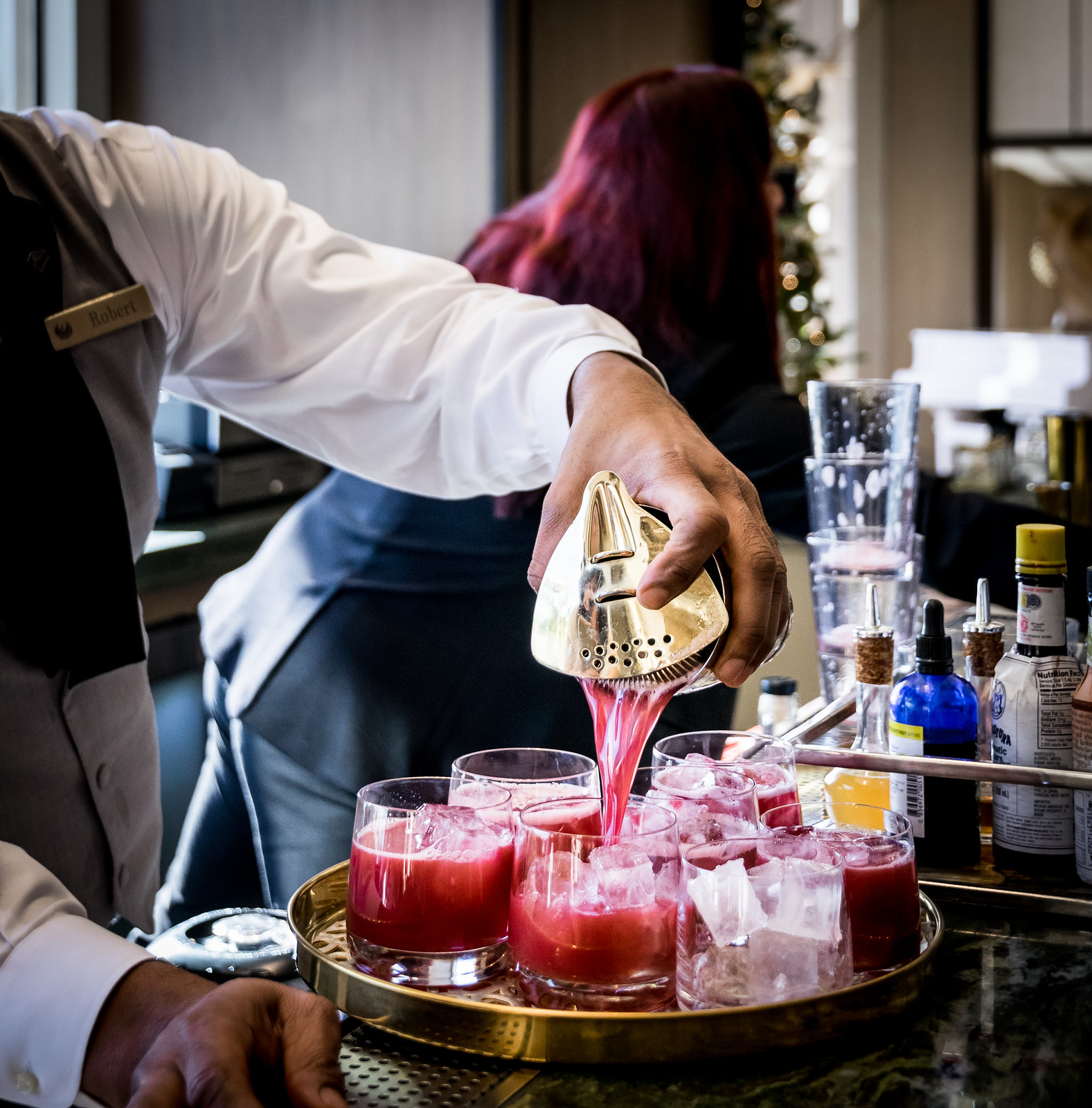 Robert pouring a round of Cortez cocktails: tequila & mezcal, hibiscus syrup, lemon,  and orange bitters