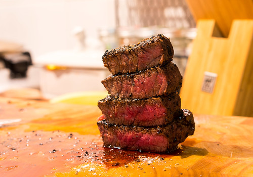 Four slices of prime steak on a cutting board