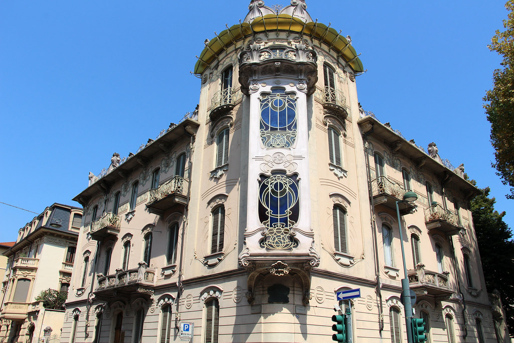 Torino - Casa Fenoglio-Lafleur: A large light-colored building with ornamental windows and a central, corner tower. 