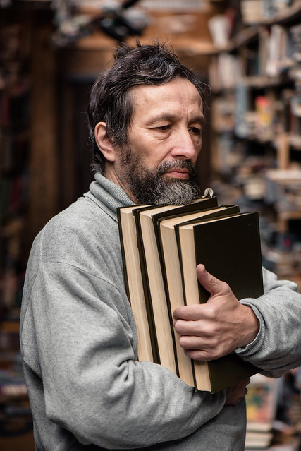 Portrait of authentic senior man on book market