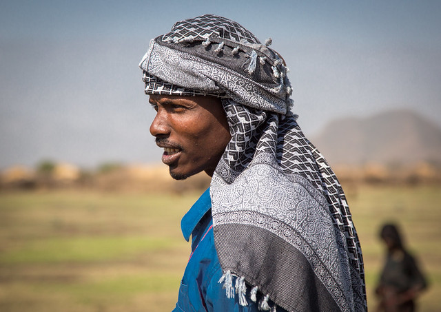 Oromo men with a headscarf  in front of his village, Amhara region, Artuma, Ethiopia