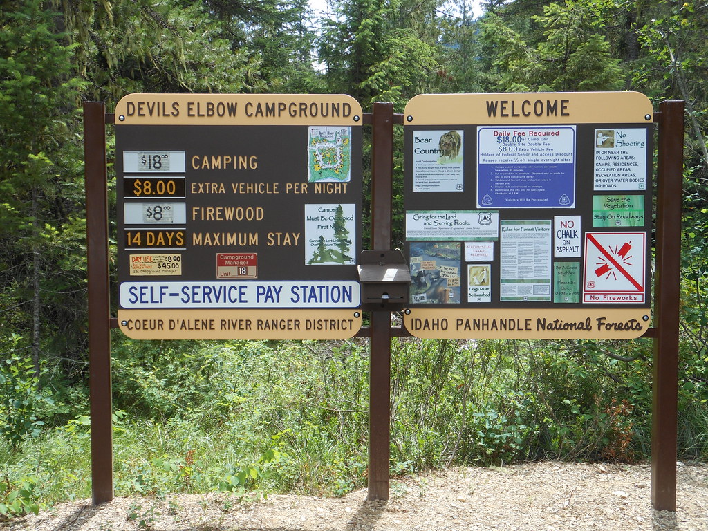 A Forest Service campground welcome and fee kiosk, showing two boards, one with information on regulations, the other with costs for camping, extra vehicles, firewood, and other information.